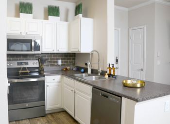 A kitchen with white cabinets and stainless steel appliances